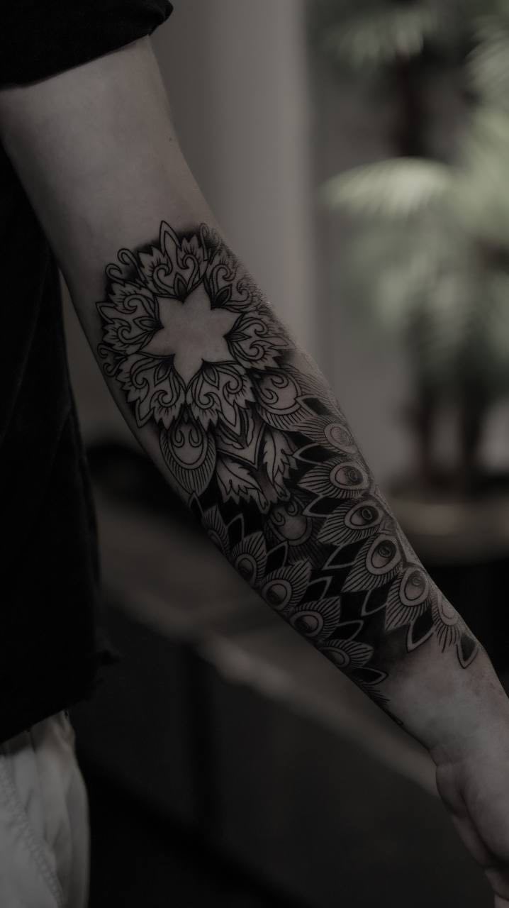 Geometric floral dotwork mandala tattoo on the forearm