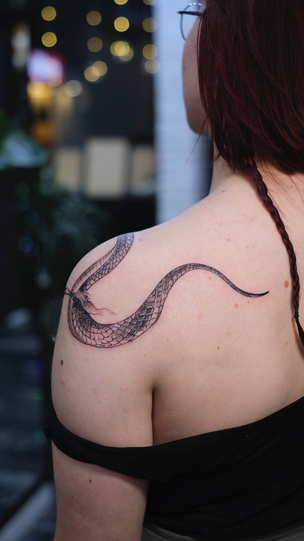 Fine-Line Schlangen-Tattoo ueber Schulter und Ruecken; filigranes Single-Needle Schlangen-Design