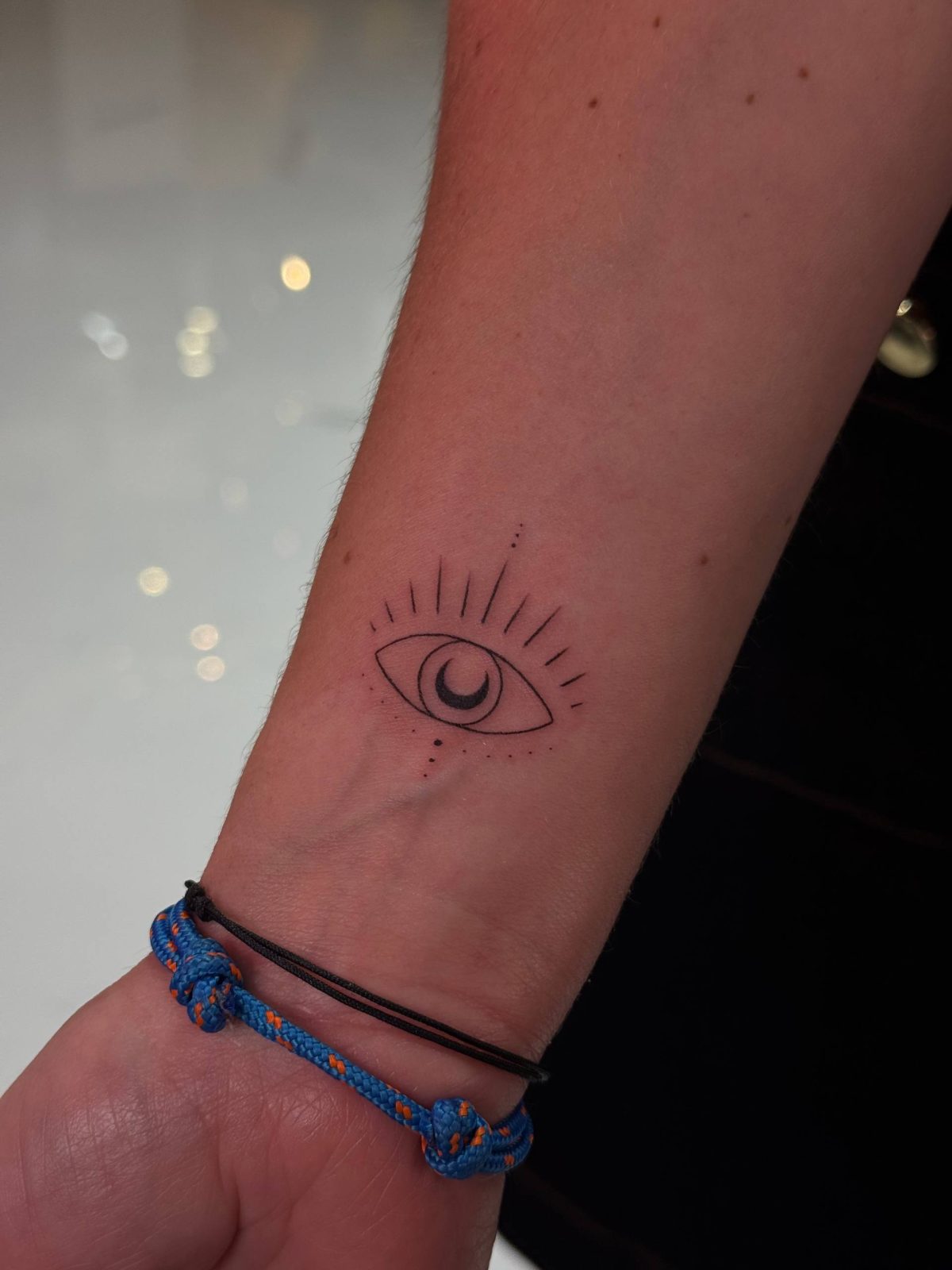 Minimalistisches Fine-Line Nazar-Auge-Tattoo am Handgelenk