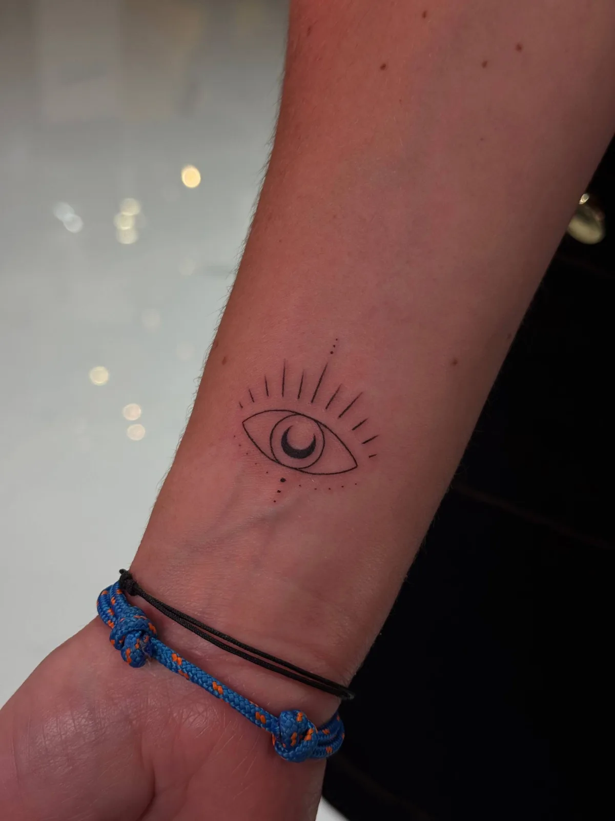 Minimalistisches Fine-Line Nazar-Auge-Tattoo am Handgelenk